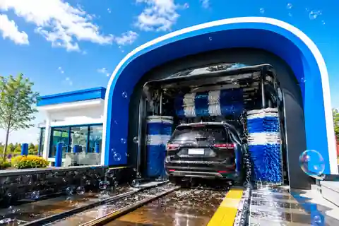 Modern blue and white car wash with a vehicle moving through the tunnel